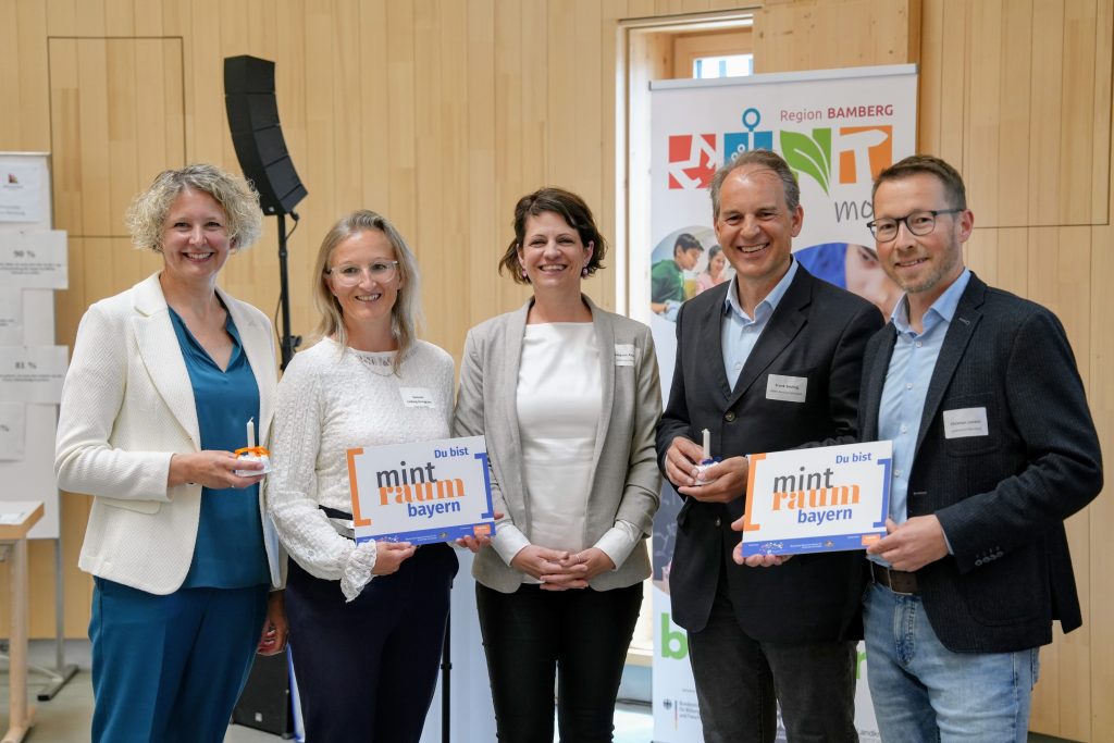 fünf Menschen freuen sich bei einer Veranstaltung über den Beitritt der MINT-Region Bamberg zum MINTraum bayern