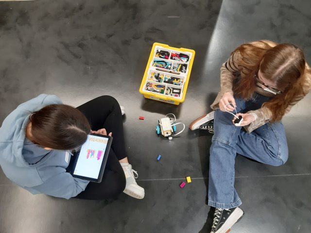 zwei Mädchen programieren eine Roboter mit Scratch