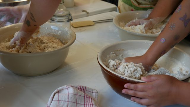 Personen kneten Teig in Schüsseln