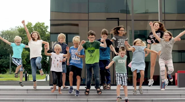 Gruppe von Kindern springt fröhlich die Treppe hinunter