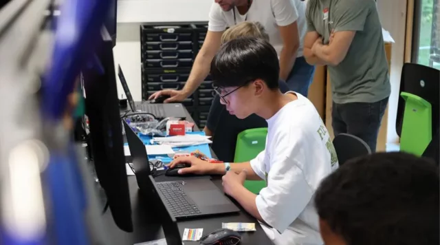 Gruppenarbeit am Computer in einem modernen Workshop.