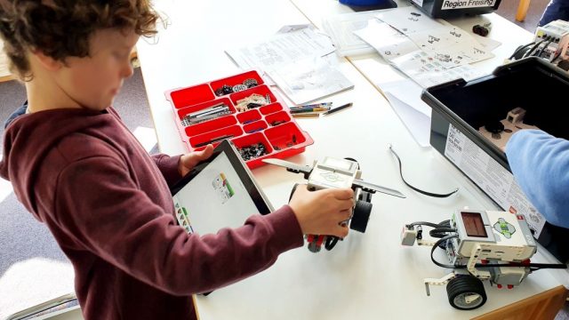 Kind steuern einen Roboter mit einem Tablet
