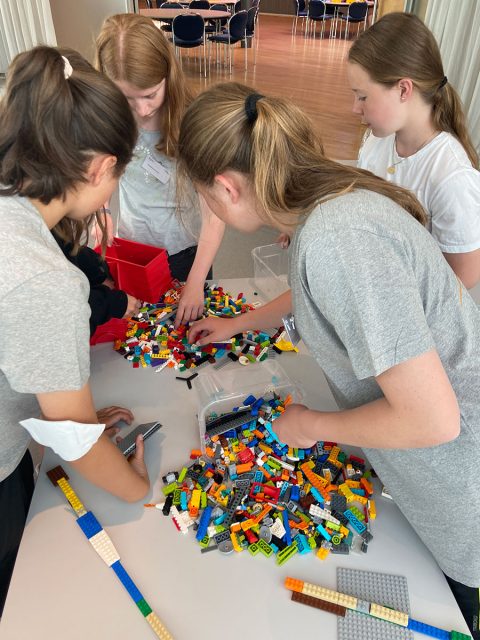 fünf Mädchen spielen und bauen mit Bausteinen