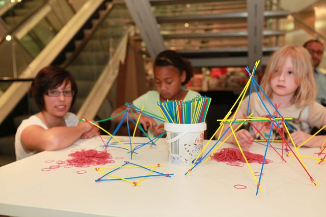 Kinder basteln geometrische Figuren aus Plastikhalmen .