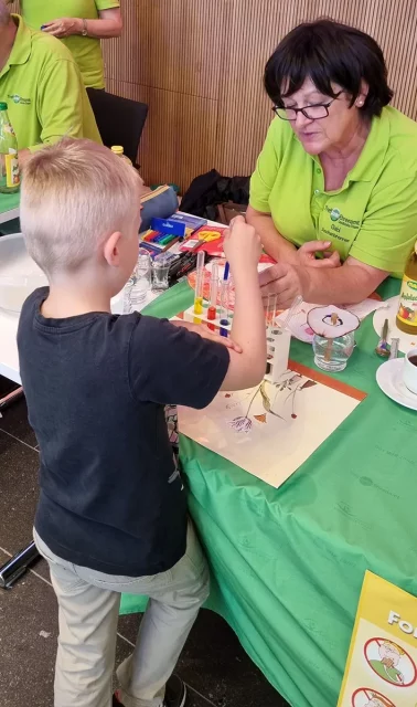 Kind experimentiert mit farbigen Flüssigkeiten und einer Pipette.