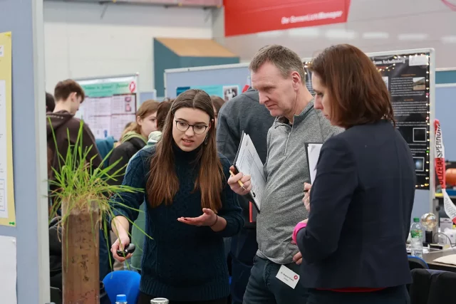 Menschen diskutieren über Pflanze auf einer Messe.