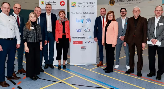 Gruppenfoto von vielen Menschen vor zwei Roll Up Bannern.