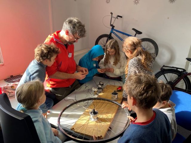 Gruppe von Kindern und Erwachsenem beim Basteln.