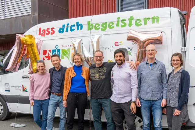 Gruppe von sechs Personen vor bemaltem Bus
