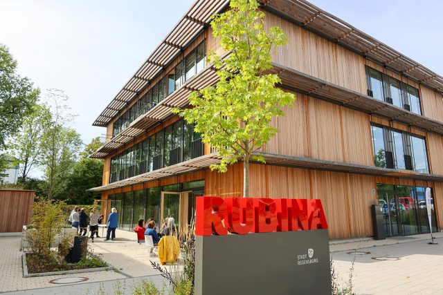 Modernes Holzgebäude mit rotem RUBINA-Schriftzug