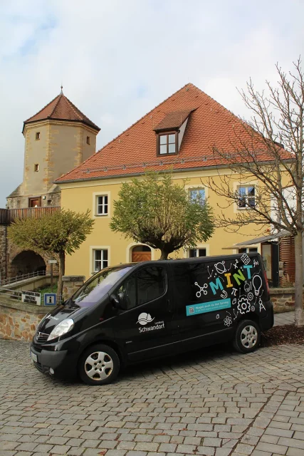 Auto der MINT-Region Schwandorf steht vor einem älteren Haus