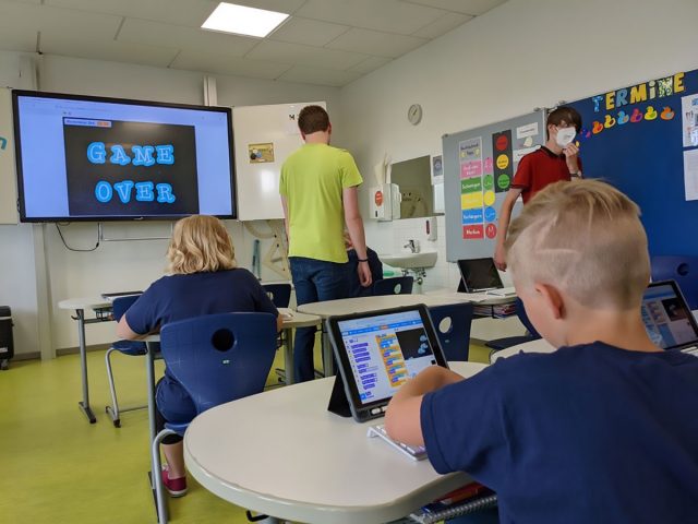 junge Schüler arbeiten in einem Klassenzimmer mit Scratch an Tablets