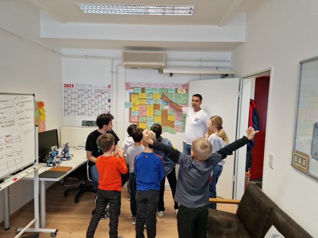 Kindergruppe im Workshop-Raum bei einer Präsentation.