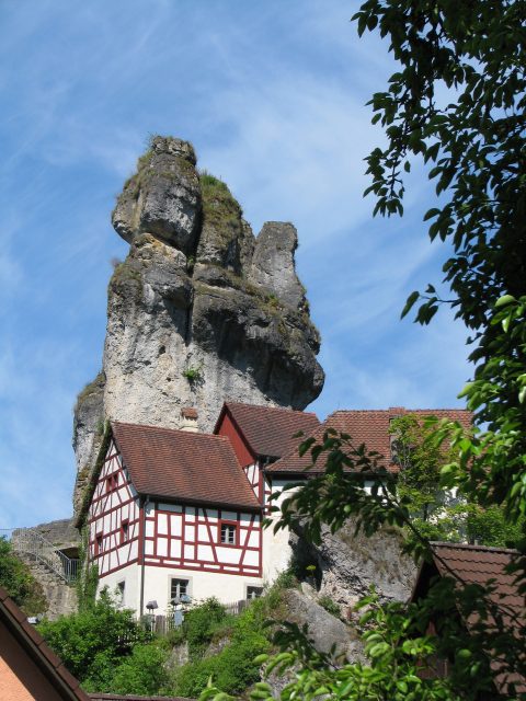 Fachwerkhaus vor großem Felsen