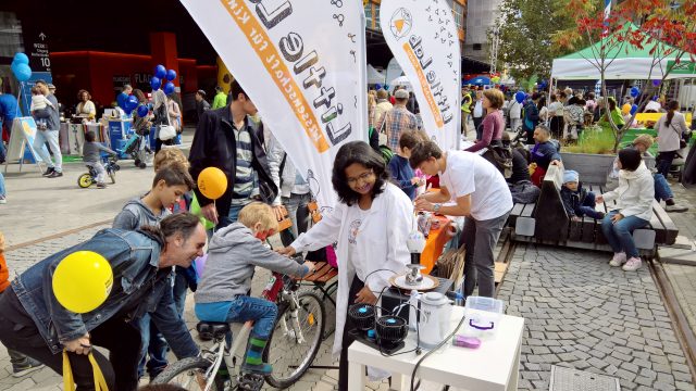 Kinder auf Fahrrädern erzeugen Energie im Freien.