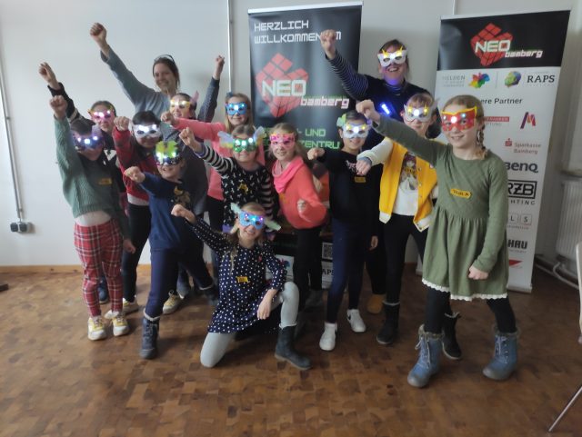 Kinder mit bunten Superheldenmasken posieren fröhlich zusammen.