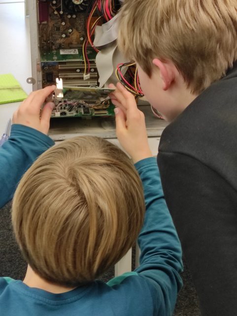 Kinder untersuchen ein technisches Gerät.