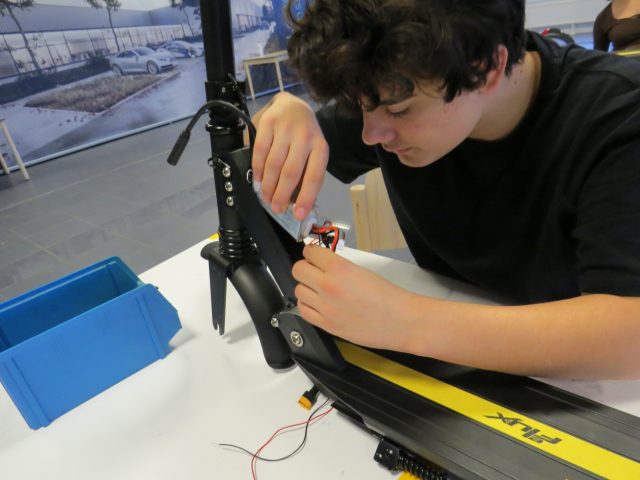 Person arbeitet an einem Elektroroller.