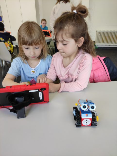 Kinder mit Tablet und Roboter.