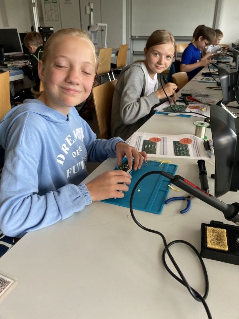 Technikkurs mit Jugendlichen, die an Projekten arbeiten.
