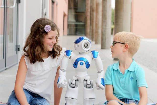 Kinder lächeln mit einem Roboter.