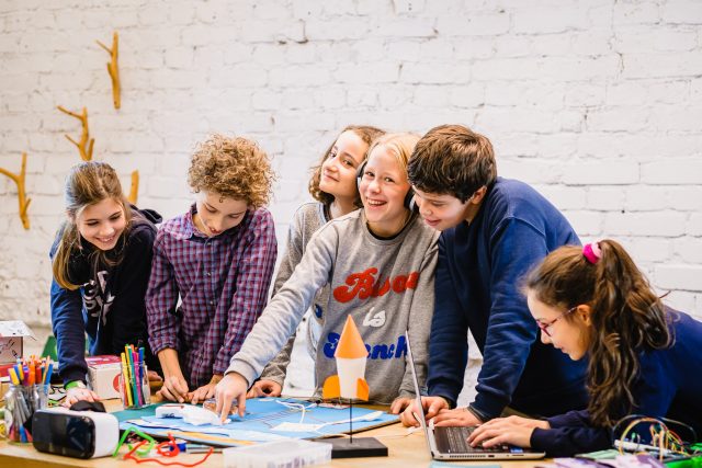 Kindergruppe bastelt eine Rakete im Team.
