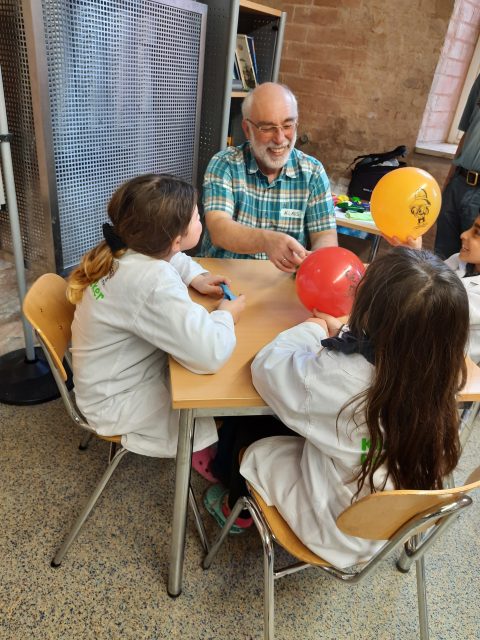 Kinder basteln am Tisch mit Luftballons.