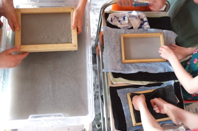 Menschen erstellen handgeschöpftes Papier mit Rahmen und Wasserbehältern.