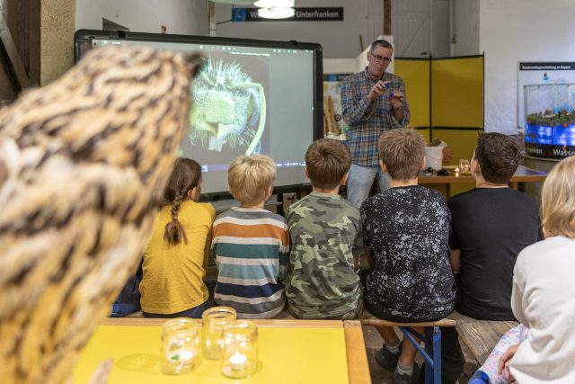 Wissenschaftler präsentiert Biologie vor Kindern auf Workshop.