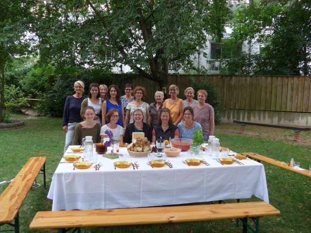 Gruppe von Frauen an einem Gartentisch bei einem Sommerfest