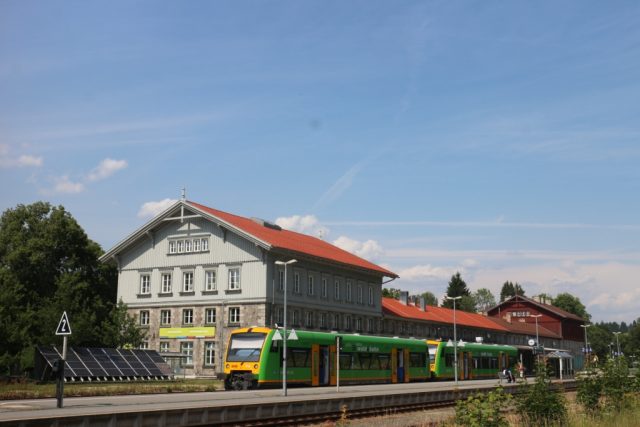 Zug am historischen Bahnhof bei schönem Wetter.