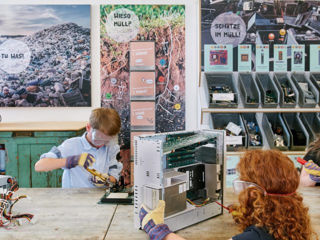 Kinder in Werkstatt beim Zerlegen eines Computers