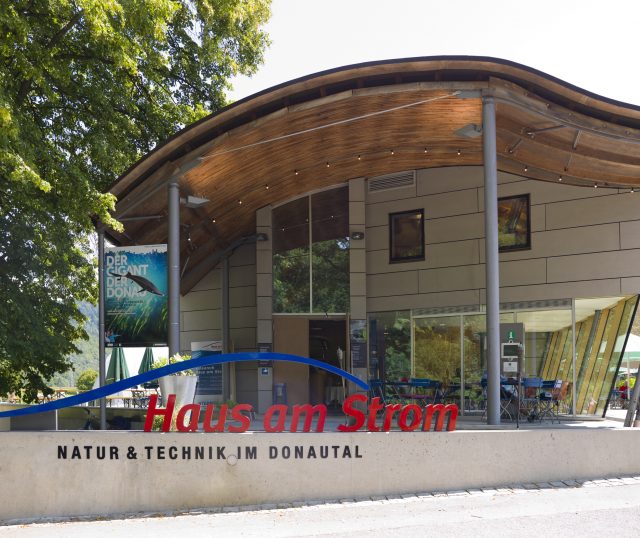 Gebäude mit Holzsdach und Glasfront.