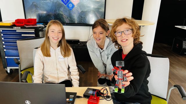 Kinder bei der Arbeit mit Elektronik und Baukästen.