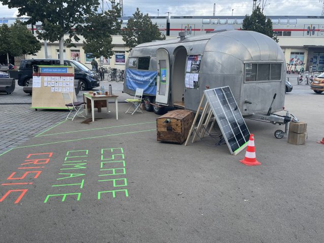 Silberner Trailer mit Klimainformation auf einem Parkplatz.