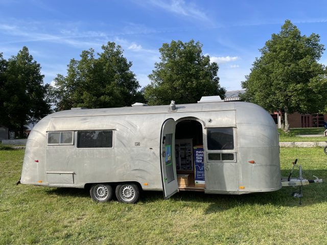 Silberner Wohnwagen auf einer Wiese