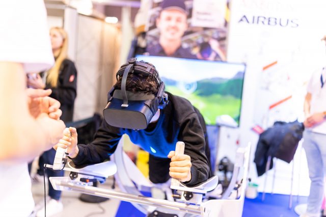 Person mit VR Headset genießt ein virtuelles Flugerlebnis.