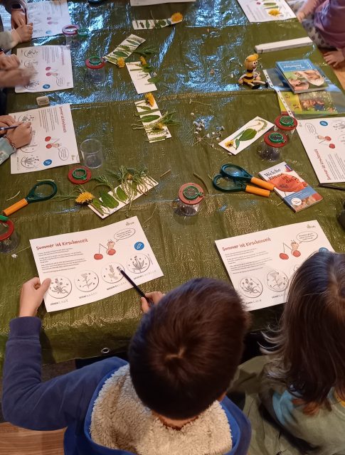 Kinder am Tisch beim Basteln mit Papier