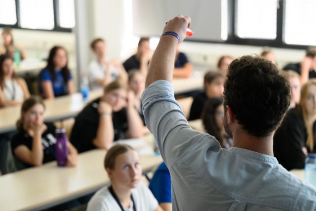 Lehrer unterrichtet Schueler im Klassenzimmer.