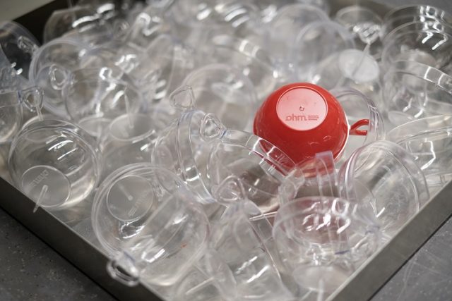 Rote Kunststoffkapsel zwischen transparenten Kapseln.