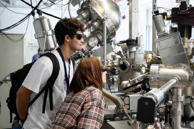 Menschen betrachten eine große wissenschaftliche Maschine