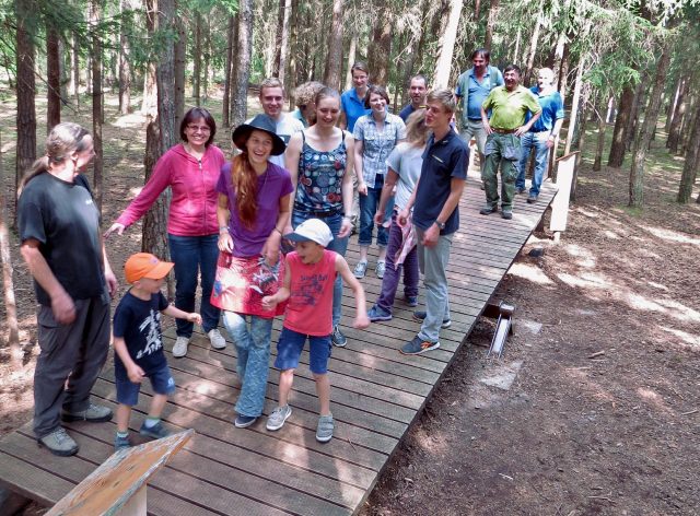 Menschen auf einer Holzwippe im Wald