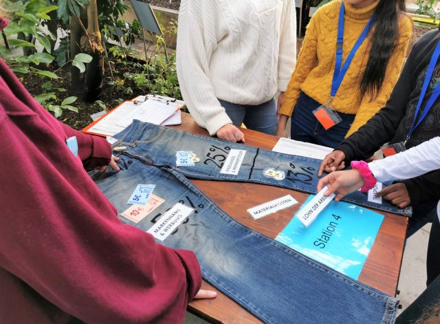 Menschen verzieren Jeans mit umweltfreundlichen Botschaften