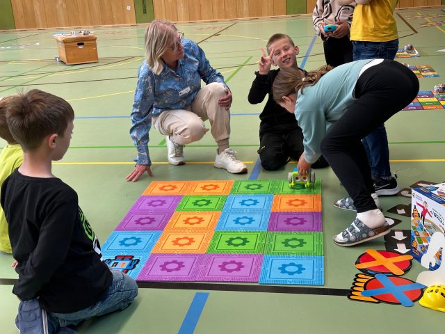 Kinder spielen mit Bodenmatten in der Turnhalle.