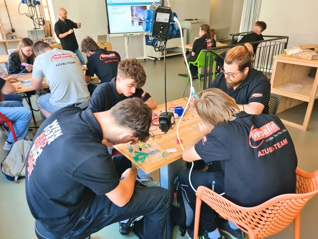 Menschen bei einem Technik Workshop am Tisch.