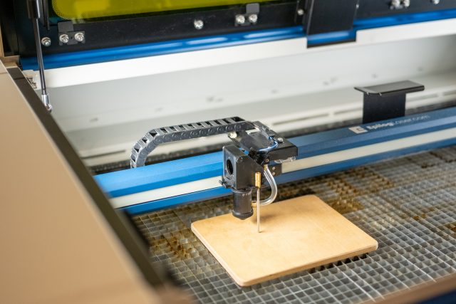 Laserschneidmaschine schneidet Holz auf einer Werkbank
