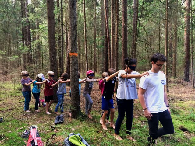 Menschen gehen blind durch einen Wald in einer Reihe.