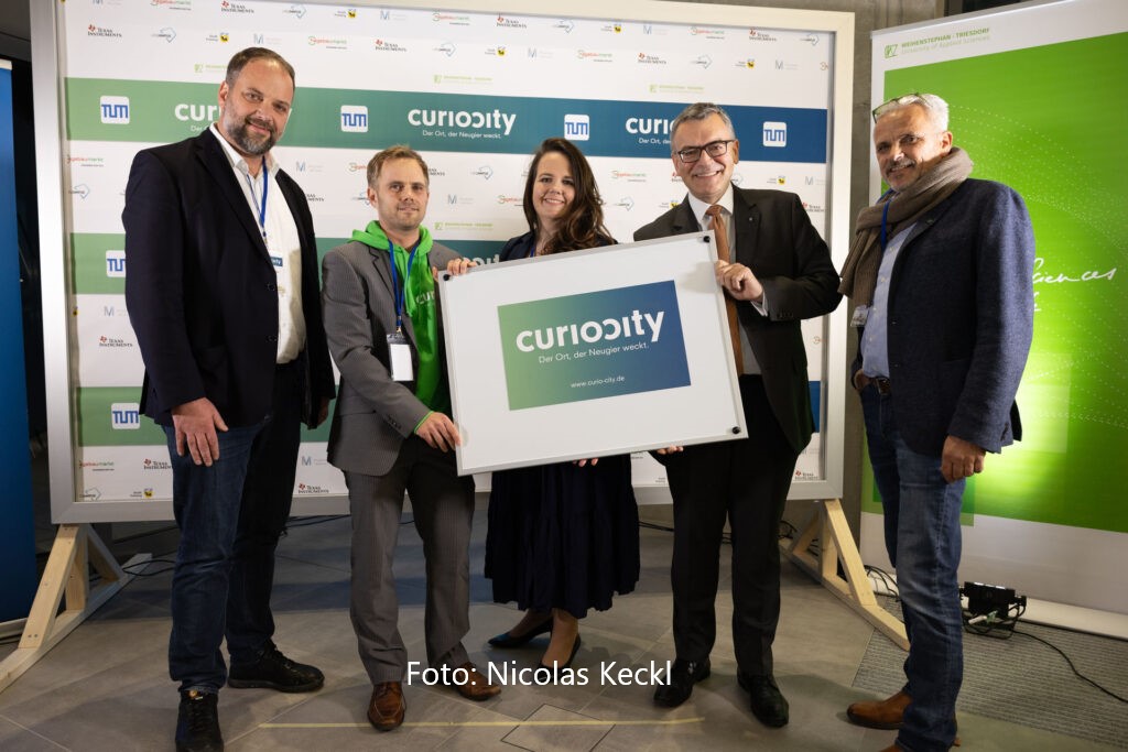 Gruppe von fünf Menschen mit Curocity Schild.