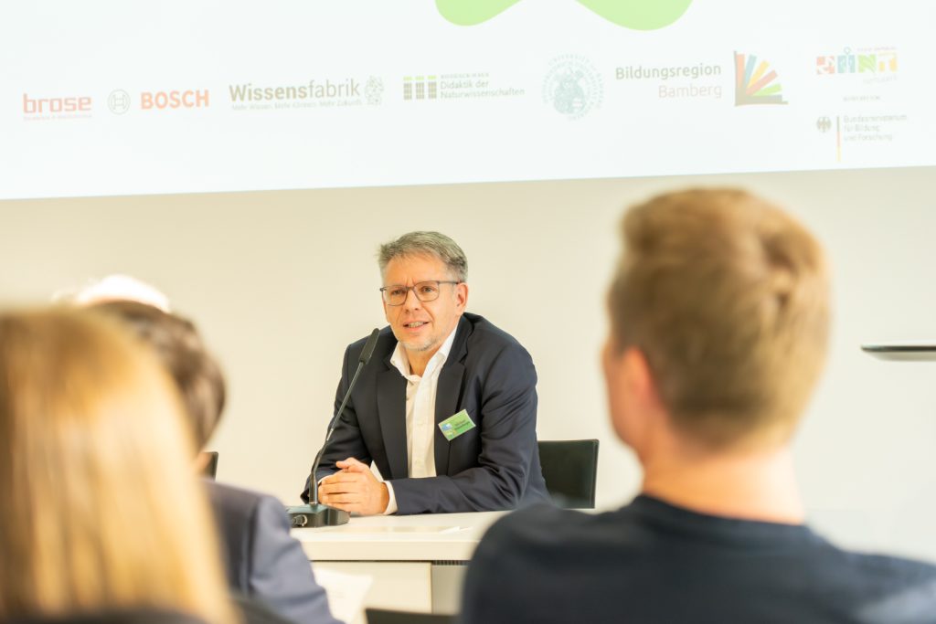Person spricht bei einer Konferenz vor Publikum.