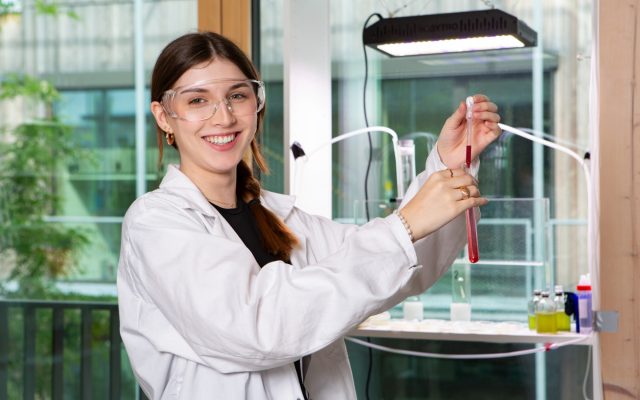Person im Labor mit Reagenzglas